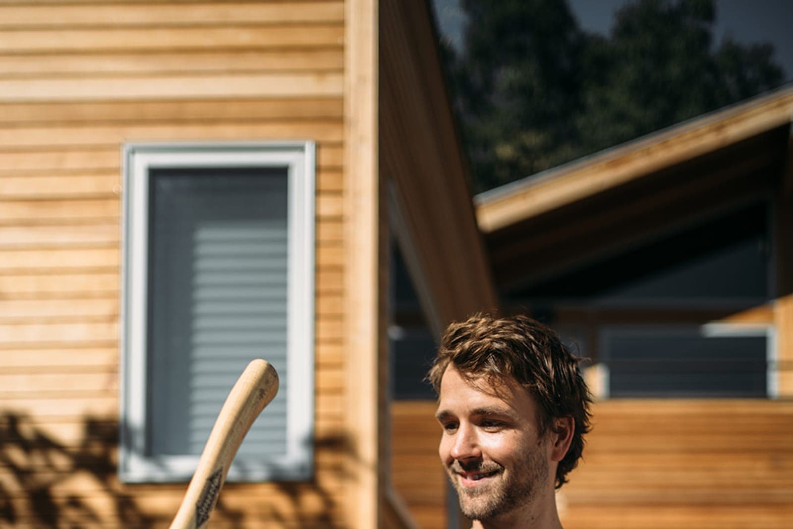 A homeowner outside modern wood-clad homes on a sunny Colorado afternoon