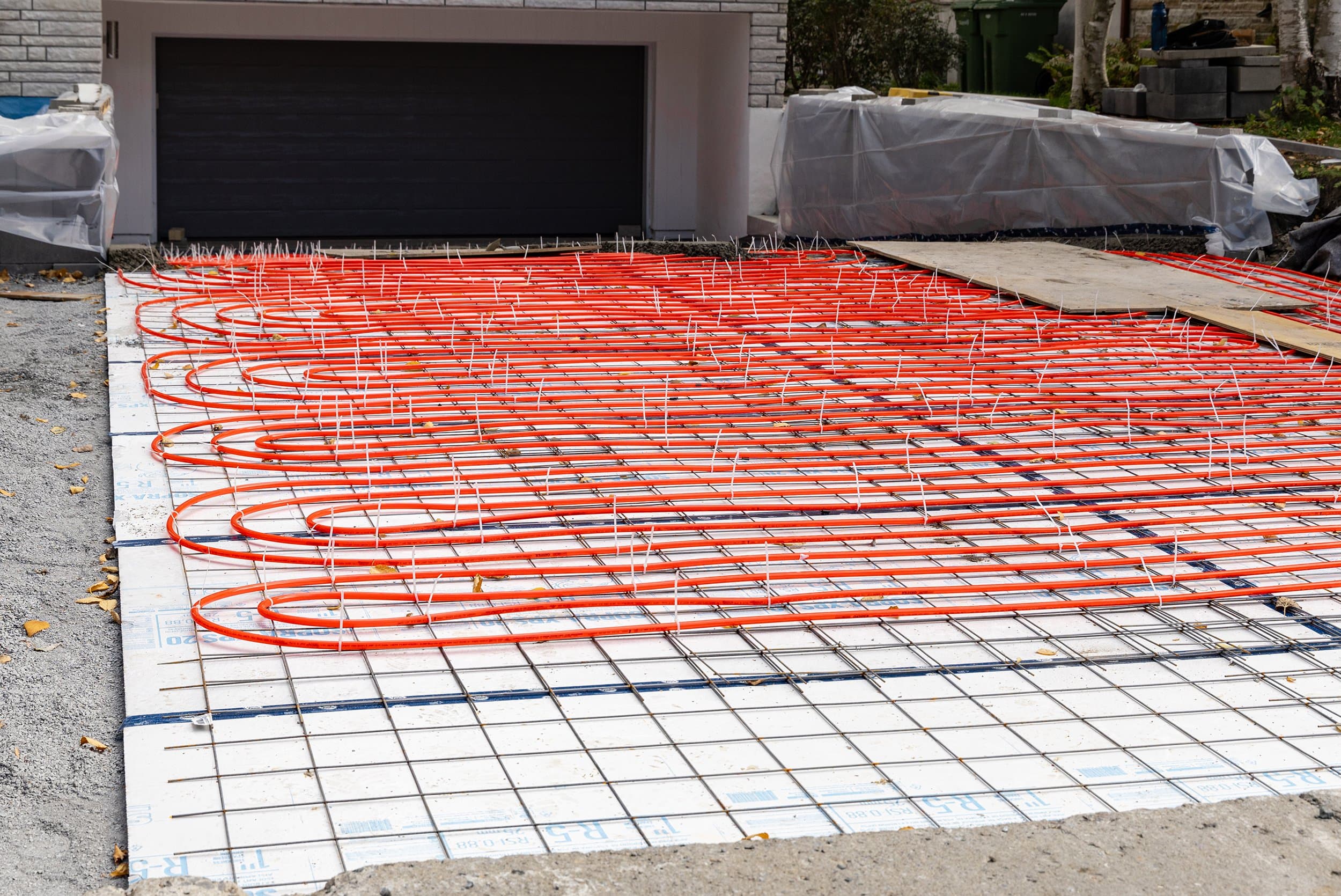 Snow-free heated driveway leading to a luxury Colorado home while surrounding ground stays covered in winter snow