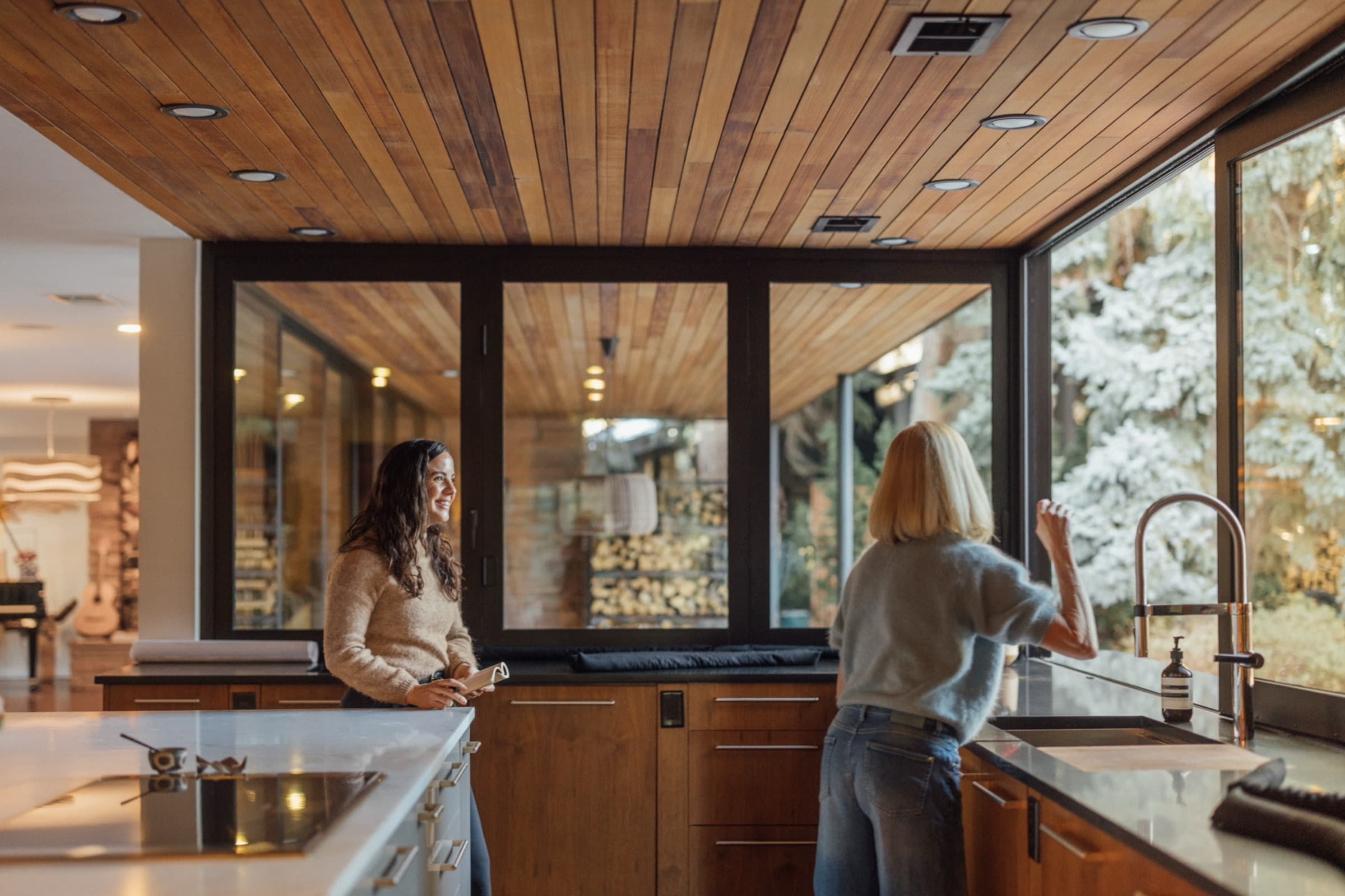 A Willow concierge talking with a homeowner in the kitchen of a modern Boulder home