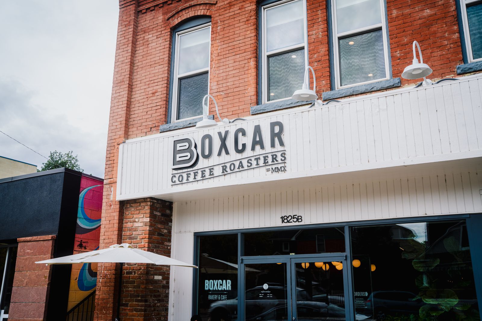 The brick storefront of Boxcar Coffee Roasters on Pearl Street in Boulder, with its sign reading Est. MMX