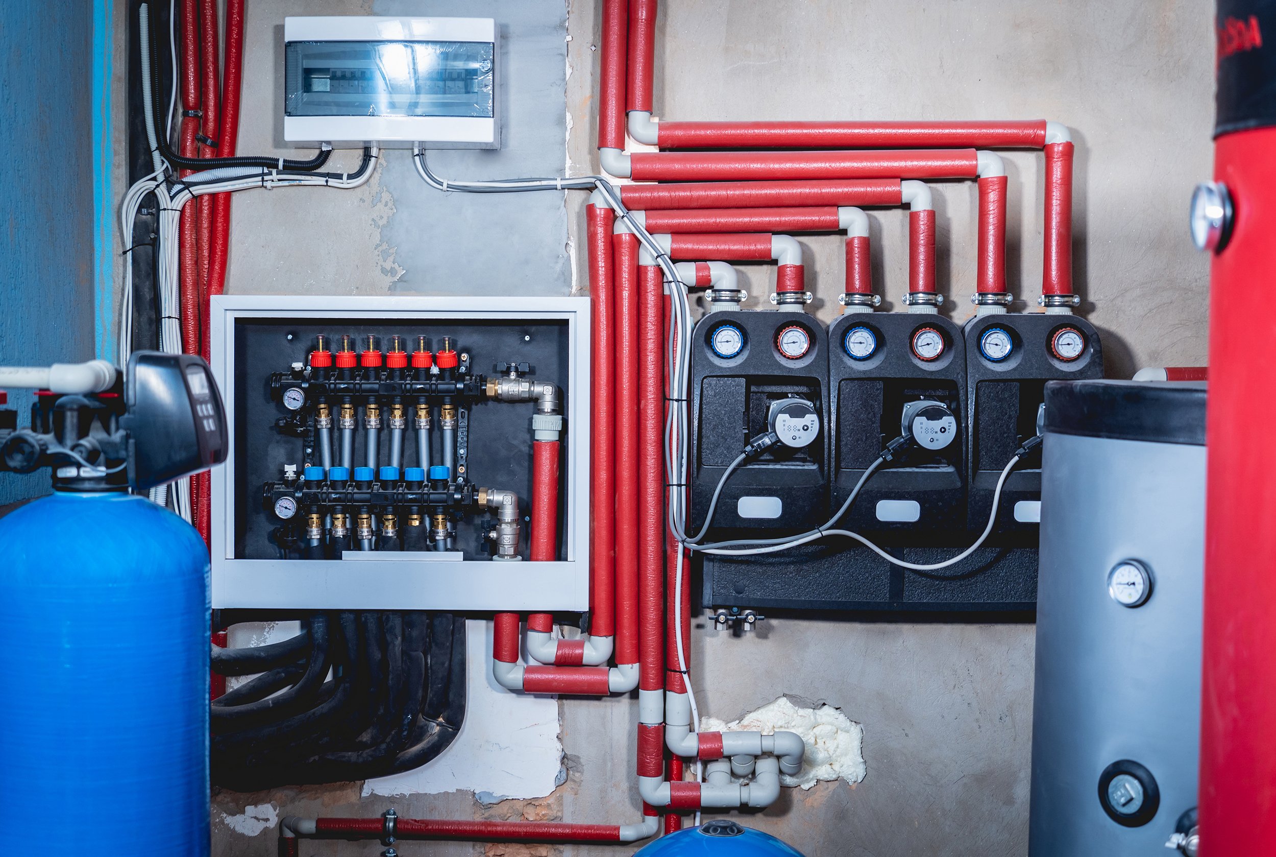 A detail photo shows the pump system for a radiant floor heating system at home. 