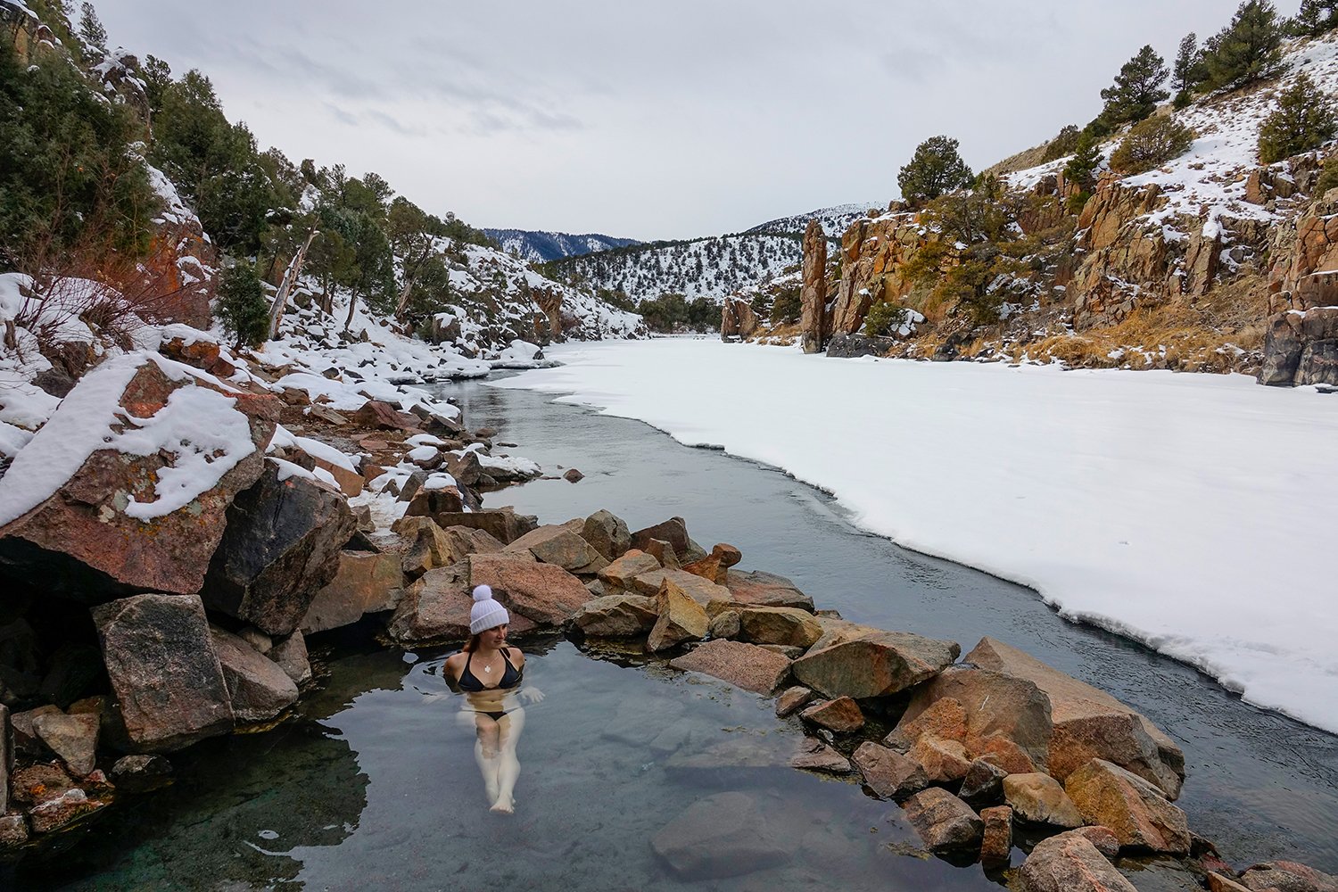  A woman soaks in a small geothermal pool along the Colorado River, also known as Radium Hot Springs, near Bond, Colorado and a day trip from Boulder for those looking for a unique natural hot springs. 