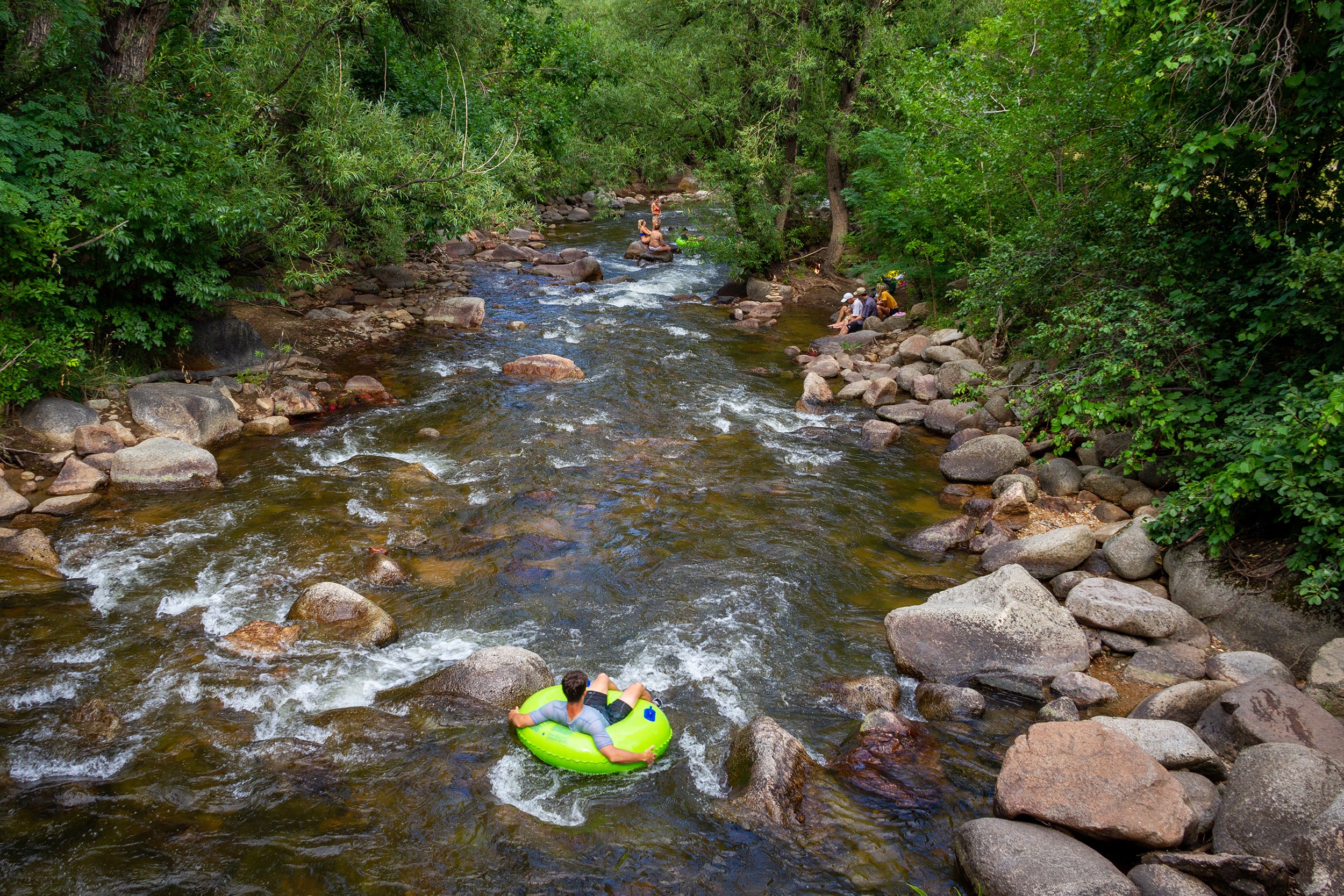  A young man wades in the water while tubing in Boulder Creek in Boulder, Colorado. 